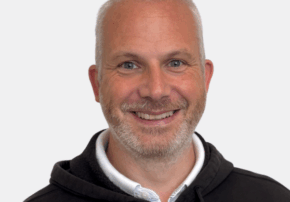 Headshot of Andre smiling in black jumper